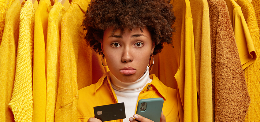 sad-frustrated-afro-woman-makes-payment-via-online-wallet-holds-credit-card-modern-cellphone